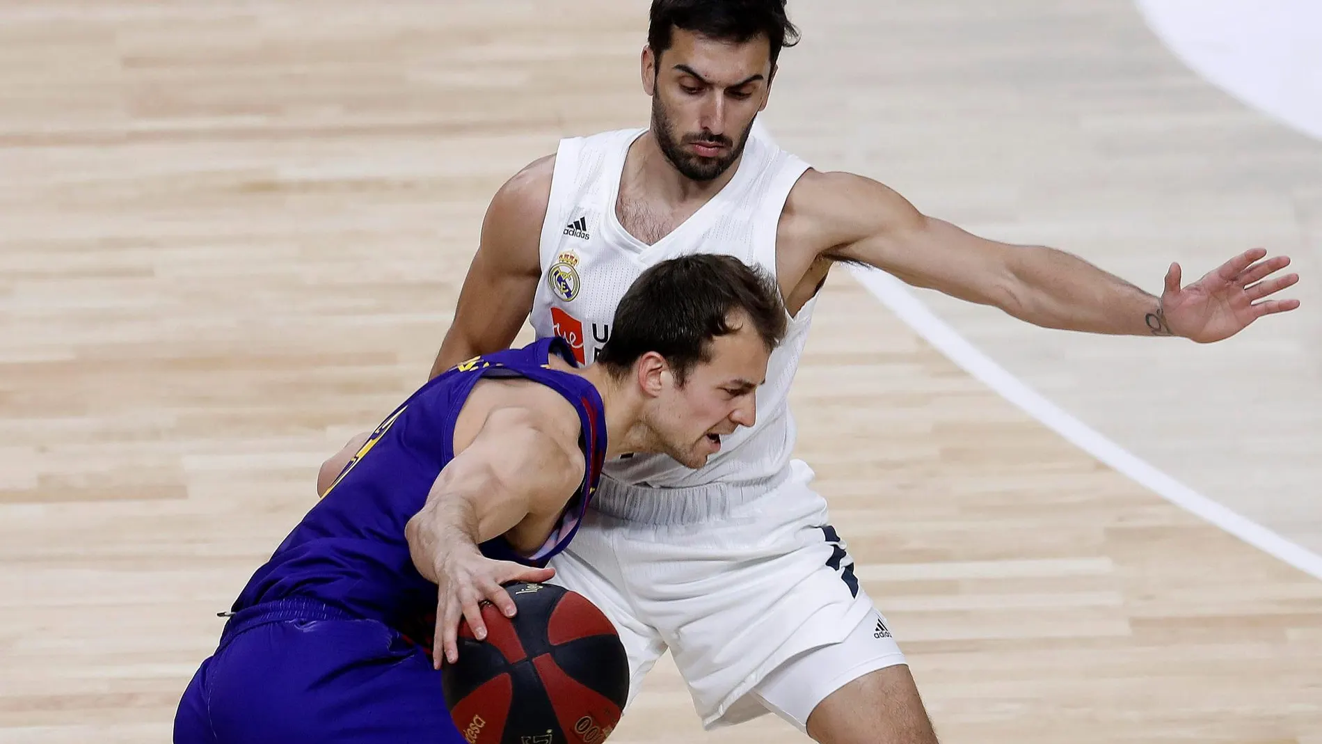 El base canadiense del FC Barcelona Lassa, Kevin Pangos (i), con el balón ante la defensa del jugador argentino del Real Madrid, Facundo Campazzo