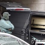 Un agente de la Guardia Civil permanece junto al furgón de los servicios funerarios, durante el traslado de los cadáveres de las dos mujeres asesinadas hoy a cuchilladas
