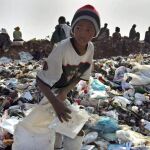 Niños recogen trozos de papel y de metal para sacar algo de dinero y aportarlo a sus familias, en un basurero de Soweto, Sudáfrica
