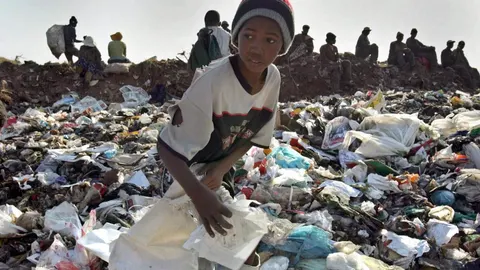 Niños recogen trozos de papel y de metal para sacar algo de dinero y aportarlo a sus familias, en un basurero de Soweto, Sudáfrica