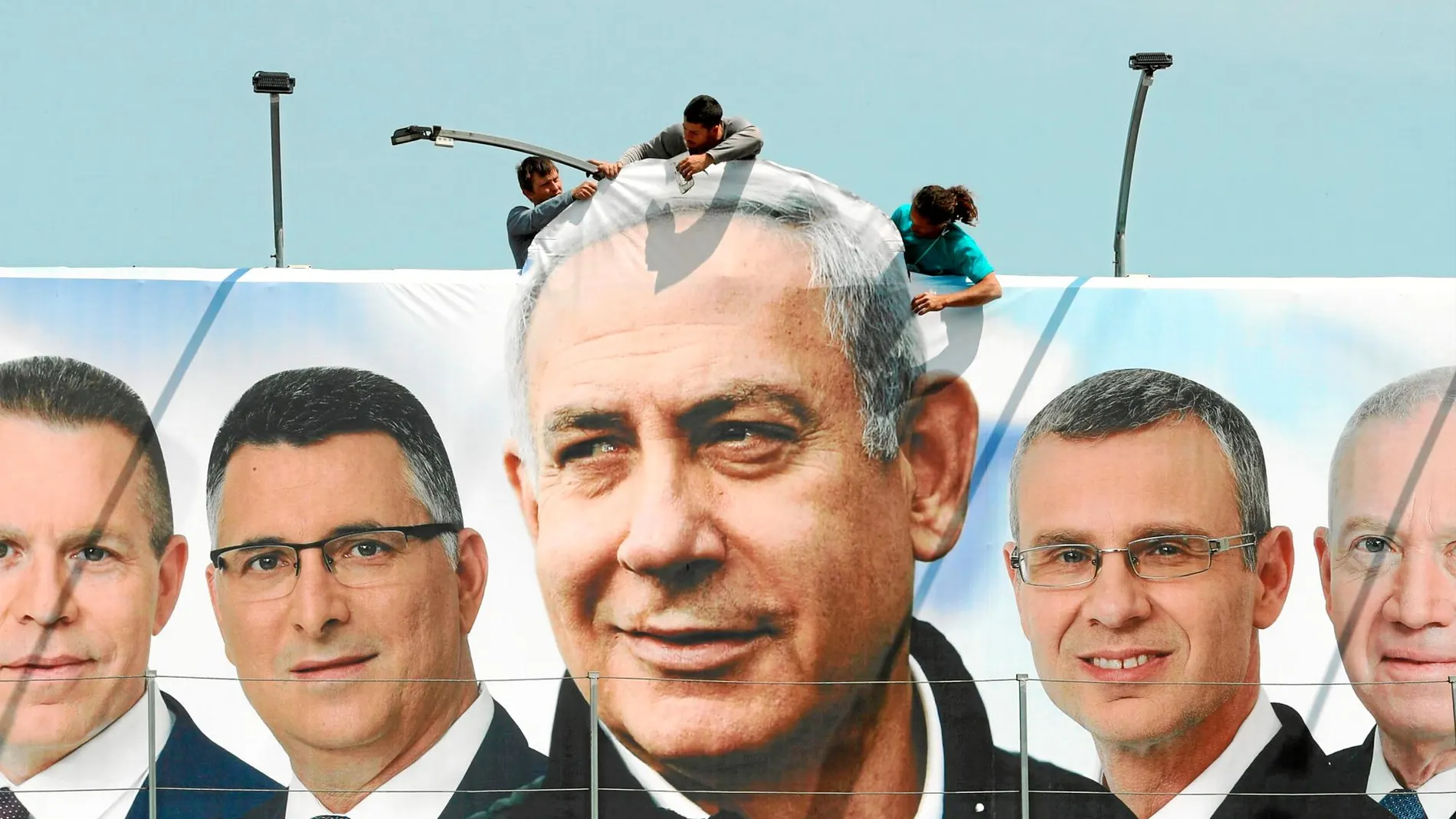 Un cartel electoral con la imagen de Netanyahu en el centro junto a la de otros candidatos, en una calle de Jerusalén / Reuters