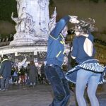 Dos jóvenes bailando frente a la plaza de la República de París, lugar donde los parisinos han rendido homenaje a las víctimas de los atentados del pasado viernes