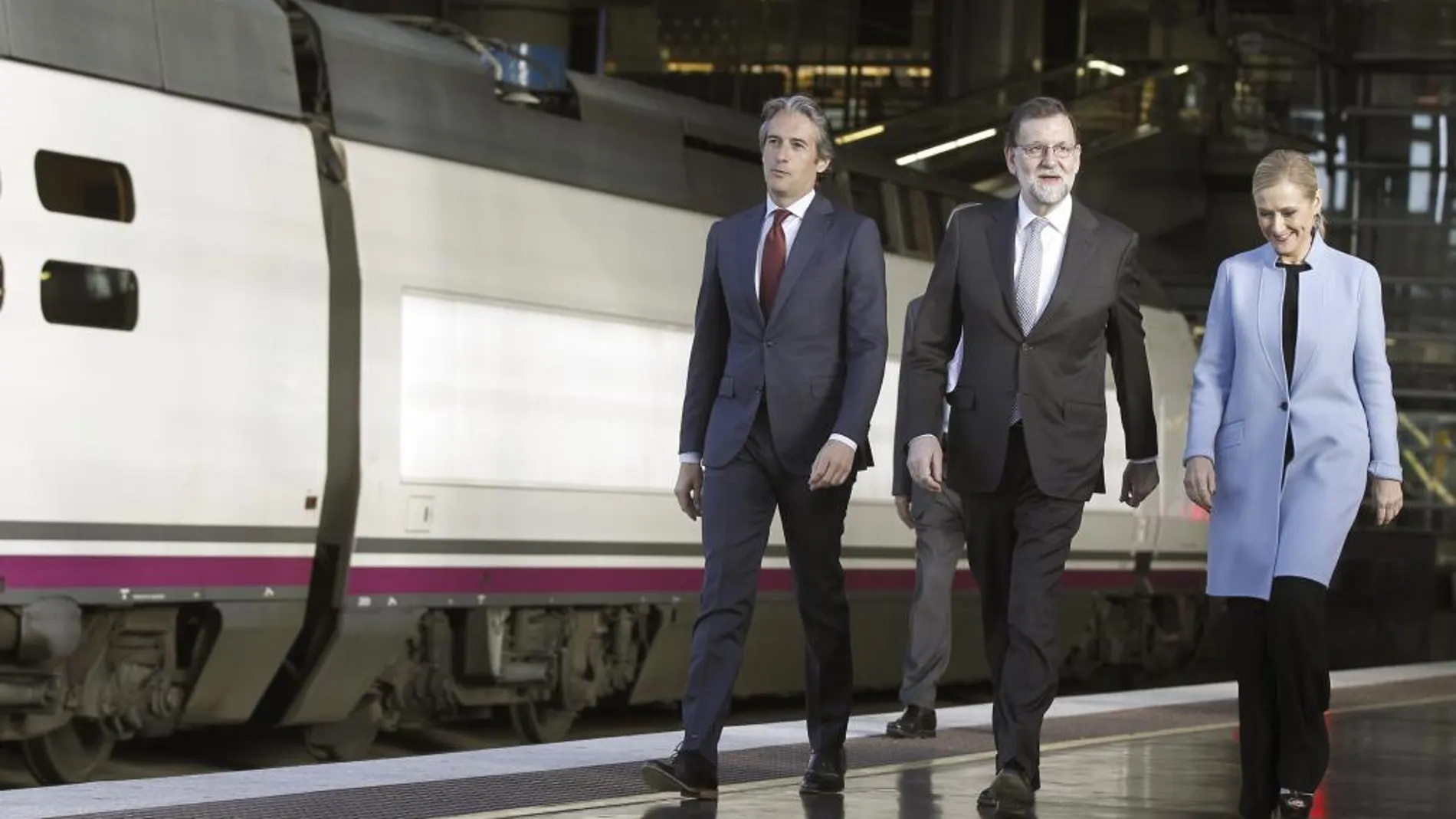 Mariano Rajoy (c), el ministro de Fomento, Iñigo de la Serna, y Cristina Cifuentes, a su llegada esta mañana a la estación de Atocha para viajar a Sevilla en el mismo AVE que hizo por primera vez este trayecto hace veinticinco años