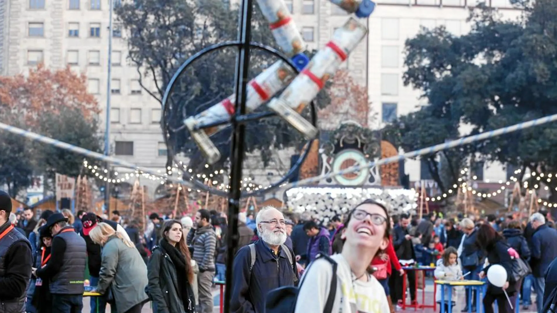 Una joven se sonríe ante uno de los números circenses que pueden disfrutarse en la plaza Cataluña