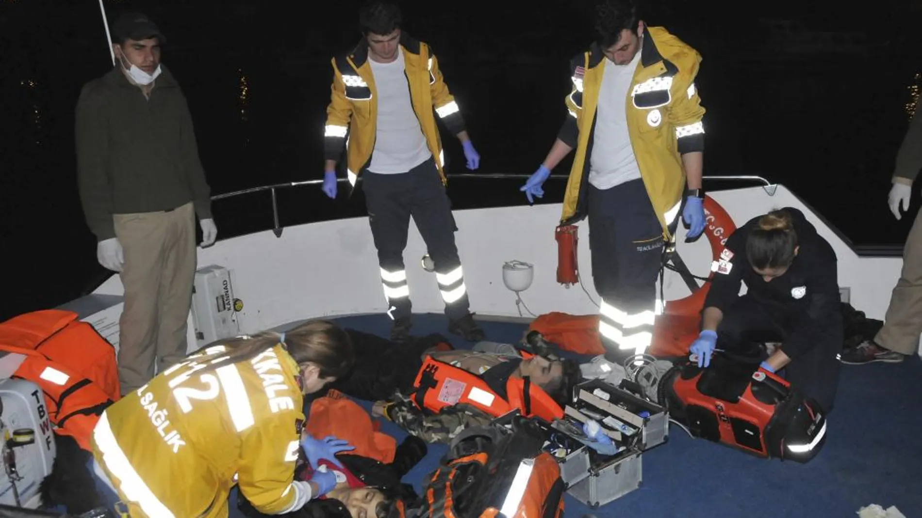 Miembros de los servicios de rescate turcos recogen a refugiados que intentaban alcanzar la costa griega en el mar Egeo