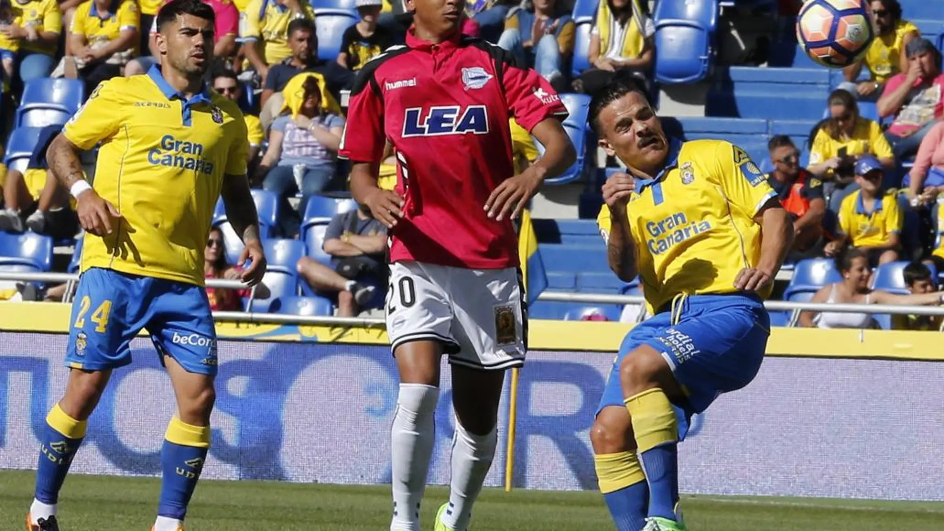 El defensa de la UD Las Palmas Roque Mesa disputa el balón con el delantero brasileño del Deportivo Alavés Deyverson