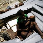Varios niños duermen sobre los restos del tejado de su escuela