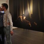 Jon y Alex, pareja que fue fotografiada por el fotógrafo danés, Mads Nissen en 2014 en san petesbrugo, se besan junto a la fotografía en la muestra de World Press Photo, en San Petesburgo en septiembrede 2015