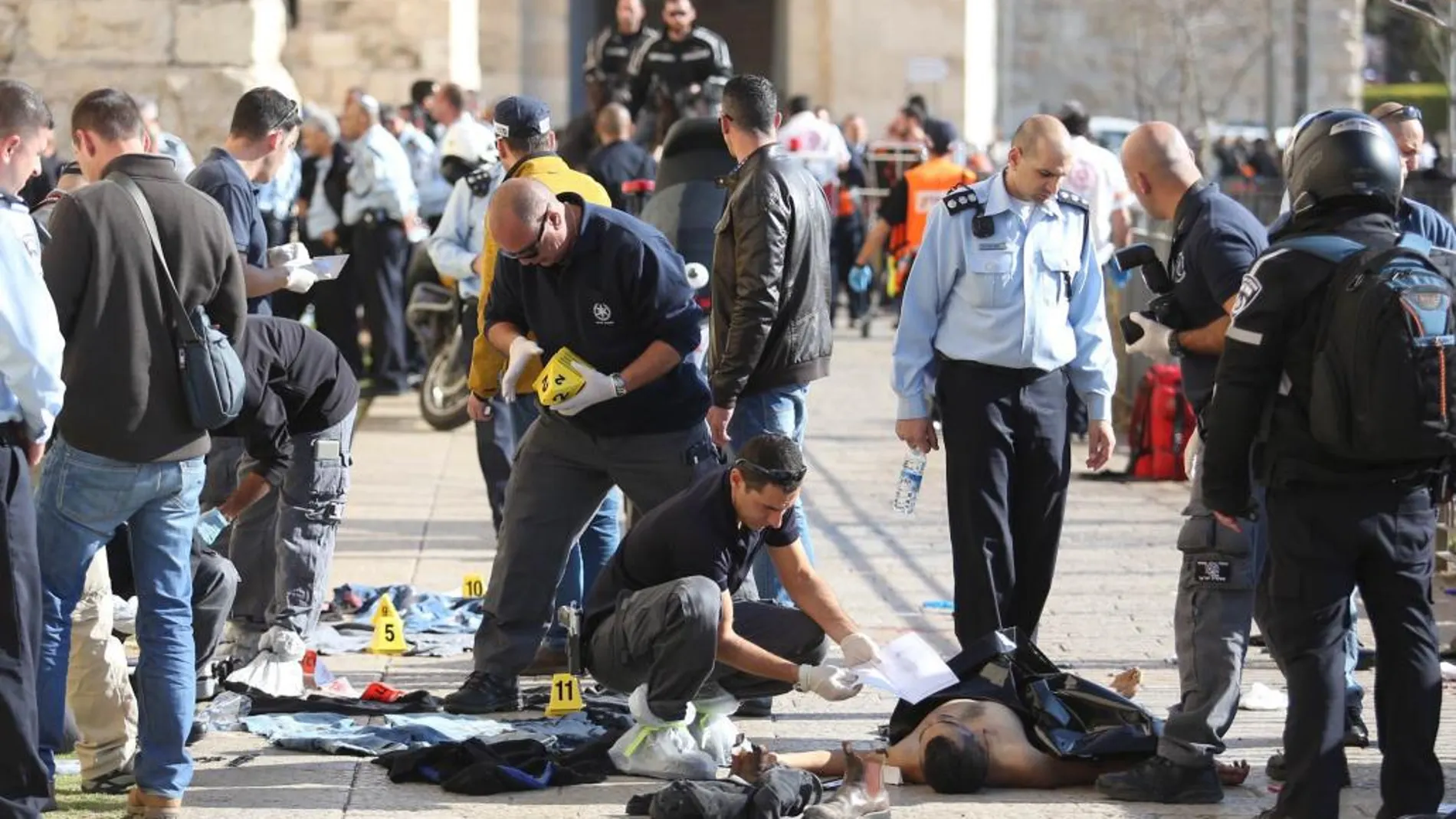 Forenses israelíes junto al cuerpo de uno de los palestinos abatidos