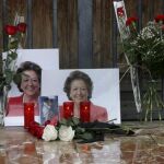 Una persona se para ante unas fotografías y flores colocadas ante el Ayuntamiento de Valencia en memoria de Rita Barberá.