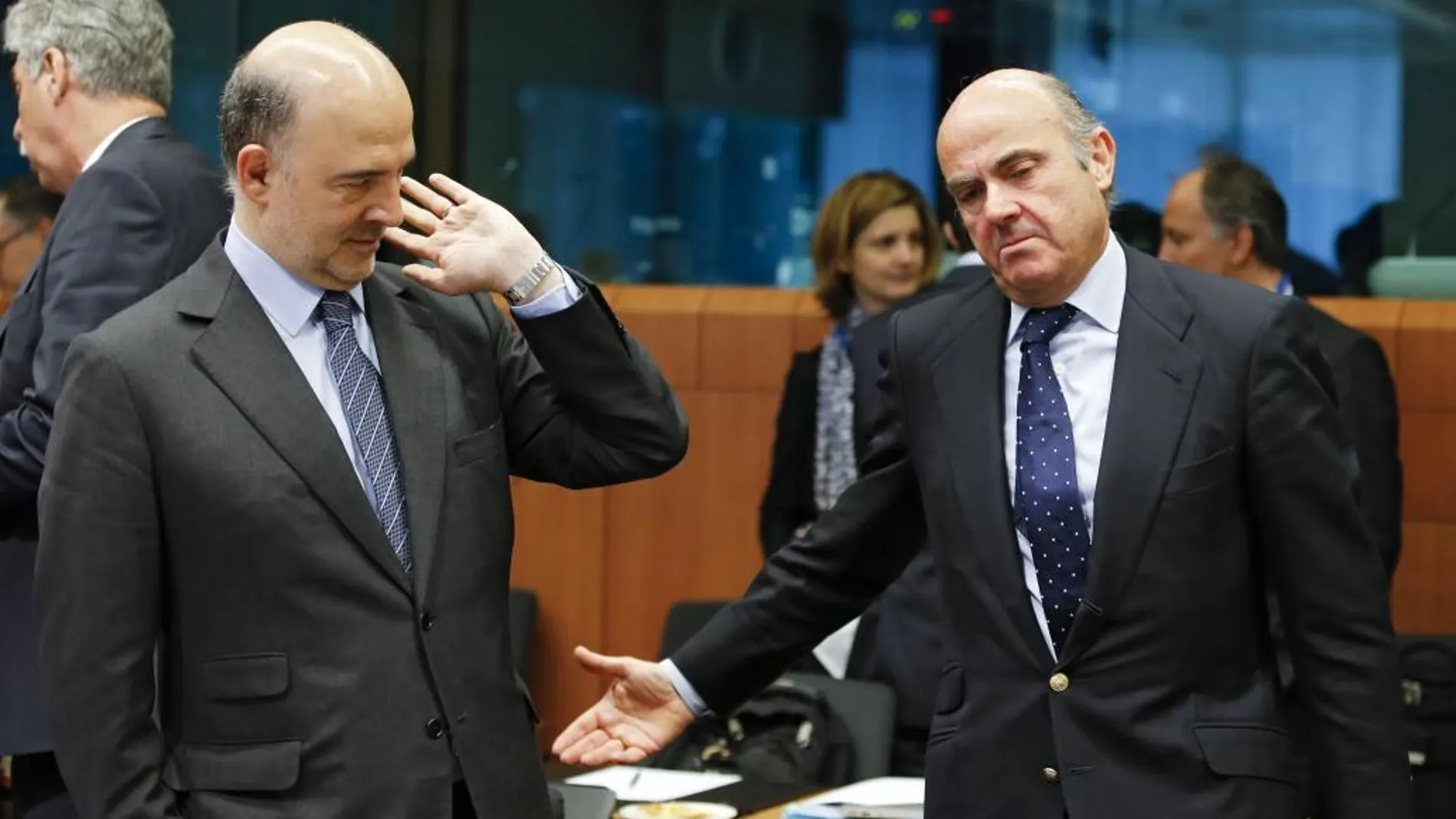 El comisario europeo de Asuntos Económicos, Pierre Moscovici, (i), conversa con el ministro español en funciones de Economía, Luis de Guindos.