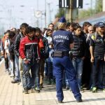 La Policía húngara vigila a los refugiados que esperan un tren para viajar a Austria