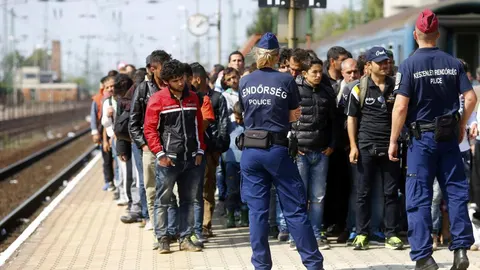 La Policía húngara vigila a los refugiados que esperan un tren para viajar a Austria