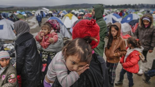 Un grupo de refugiados espera para cruzar la frontera entre Grecia y Macedonia en un campamento de refugiados cerca de Idomeni (Grecia) hoy, 9 de marzo de 2016
