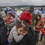 Un grupo de refugiados espera para cruzar la frontera entre Grecia y Macedonia en un campamento de refugiados cerca de Idomeni (Grecia) hoy, 9 de marzo de 2016
