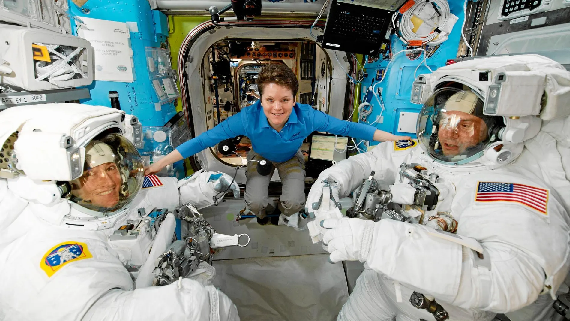 Varios astronautas antes de iniciar un viaje dentro de la Estación Espacial Internacional