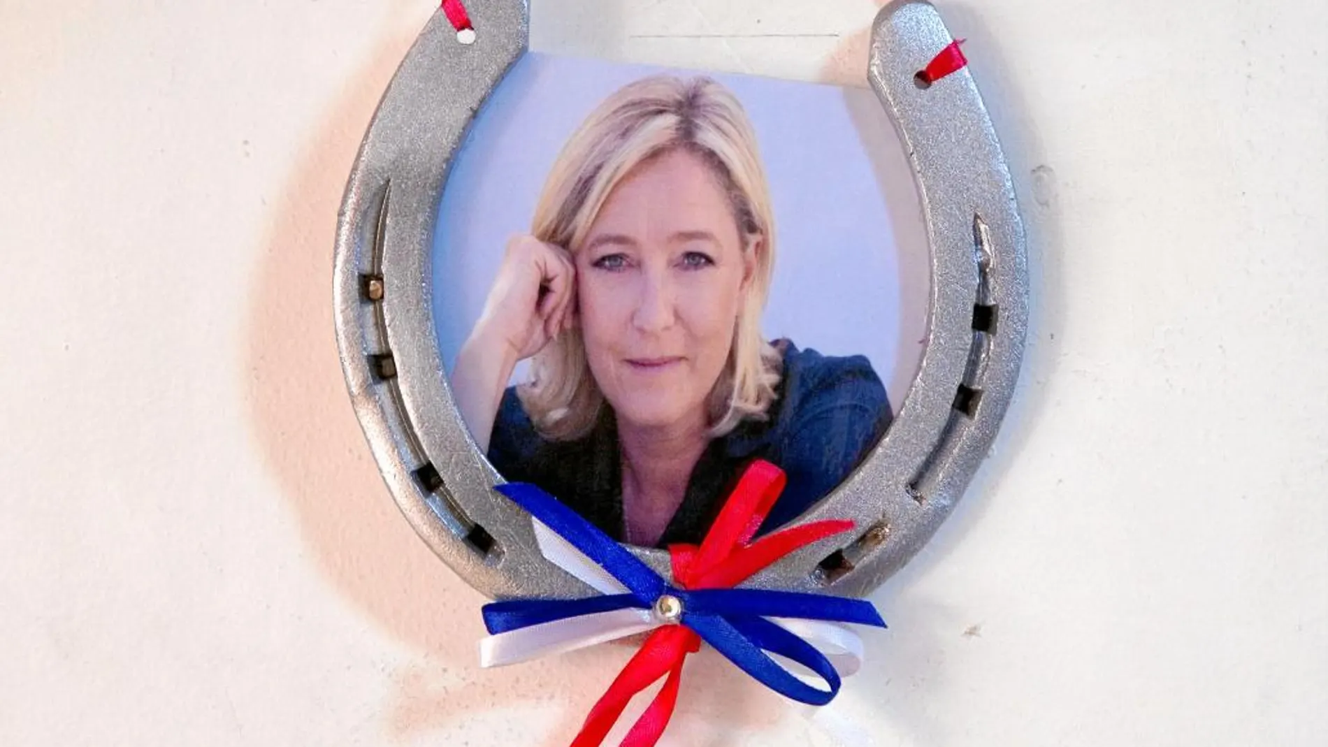 Una herradura con el retrato de la líder del FN en la sede local del partido