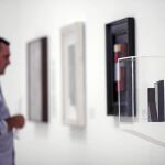 Un hombre observa varios cuadros que forman parte de la exposición del uruguayo Joaquín Torres-García, "Torres-García: un moderno en la Arcadia"