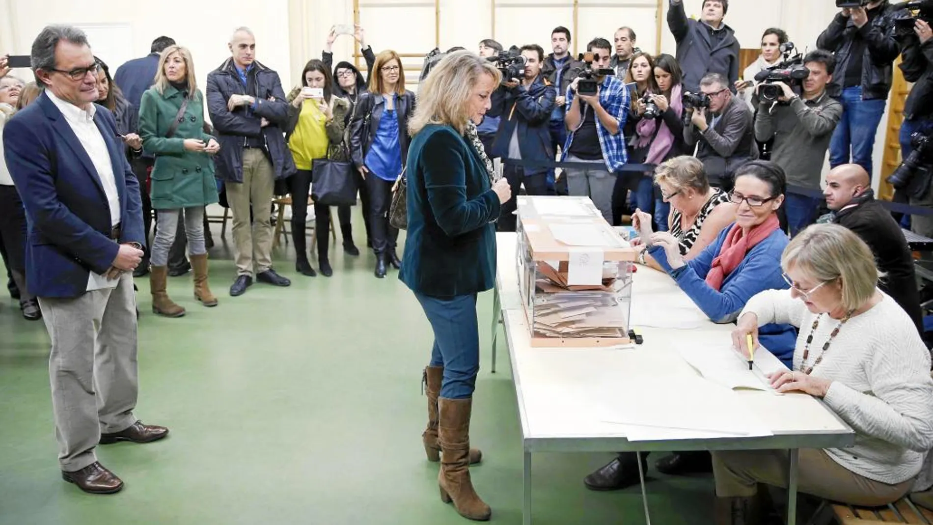Artur Mas espera su turno para depositar el voto en un colegio de Barcelona detrás de su esposa, Helena Rakosnik