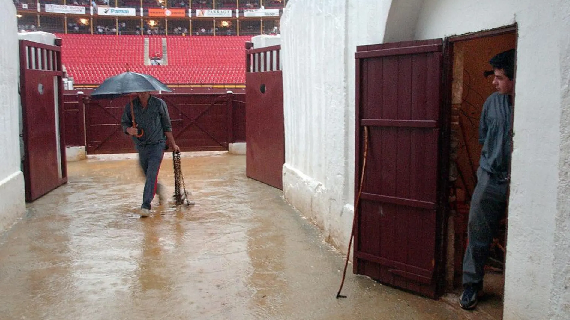 Un empleado de la plaza recoge herramientas de trabajo en la entrada al patio de caballos del coso de La Condomina