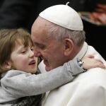 El Papa coge a un niña durante una audiencia en el Vaticano