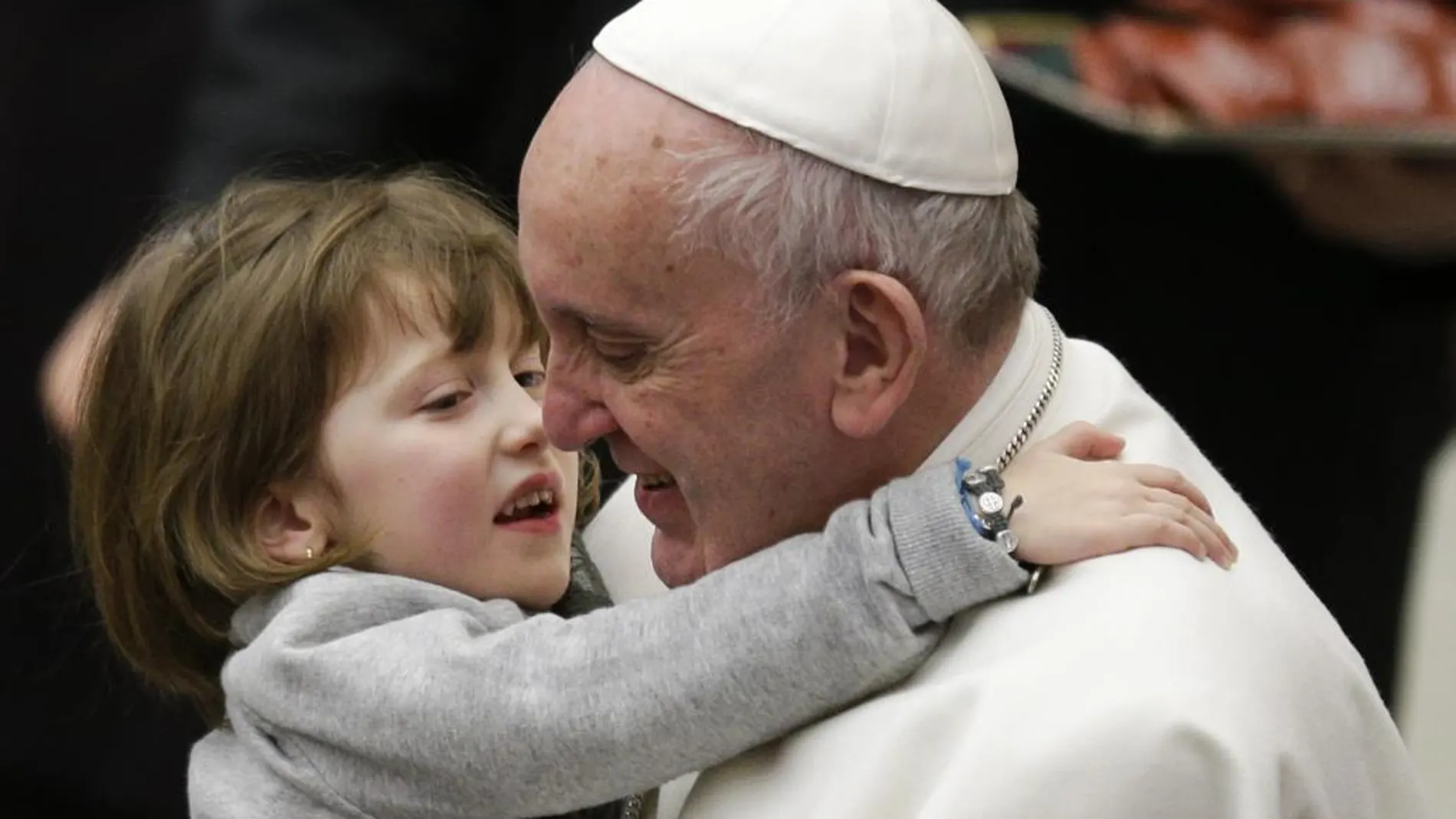 El Papa coge a un niña durante una audiencia en el Vaticano
