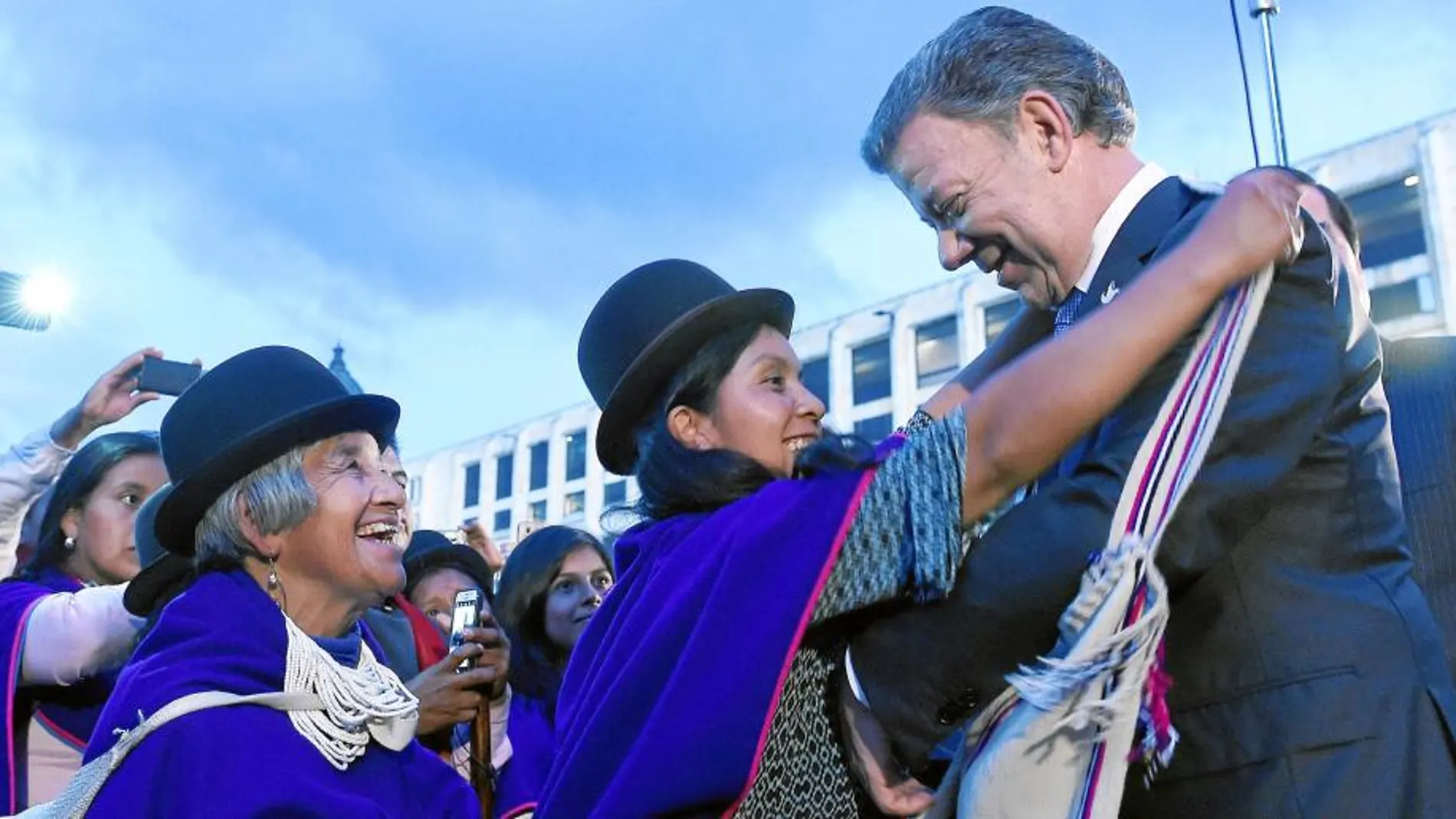 El presidente de Colombia, Juan Manuel Santos, es agasajado con varios regalos por miembros del poblado indígena de Misak, en Bogotá