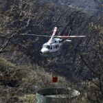 Un helicóptero recoge agua para ayudar a extinguir un incendio en León