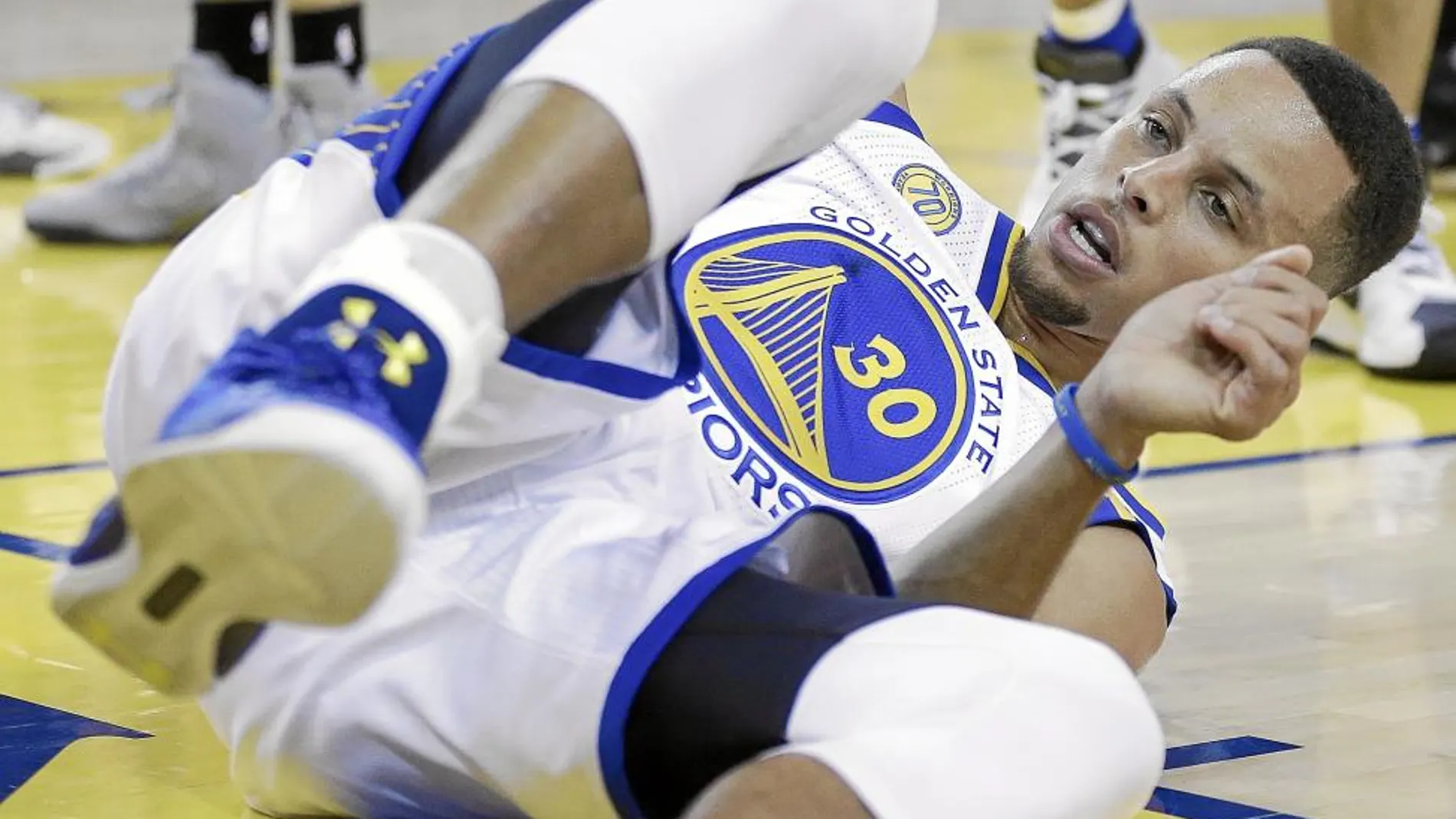 Curry, en el suelo durante el partido que abrió el curso frente a los Spurs