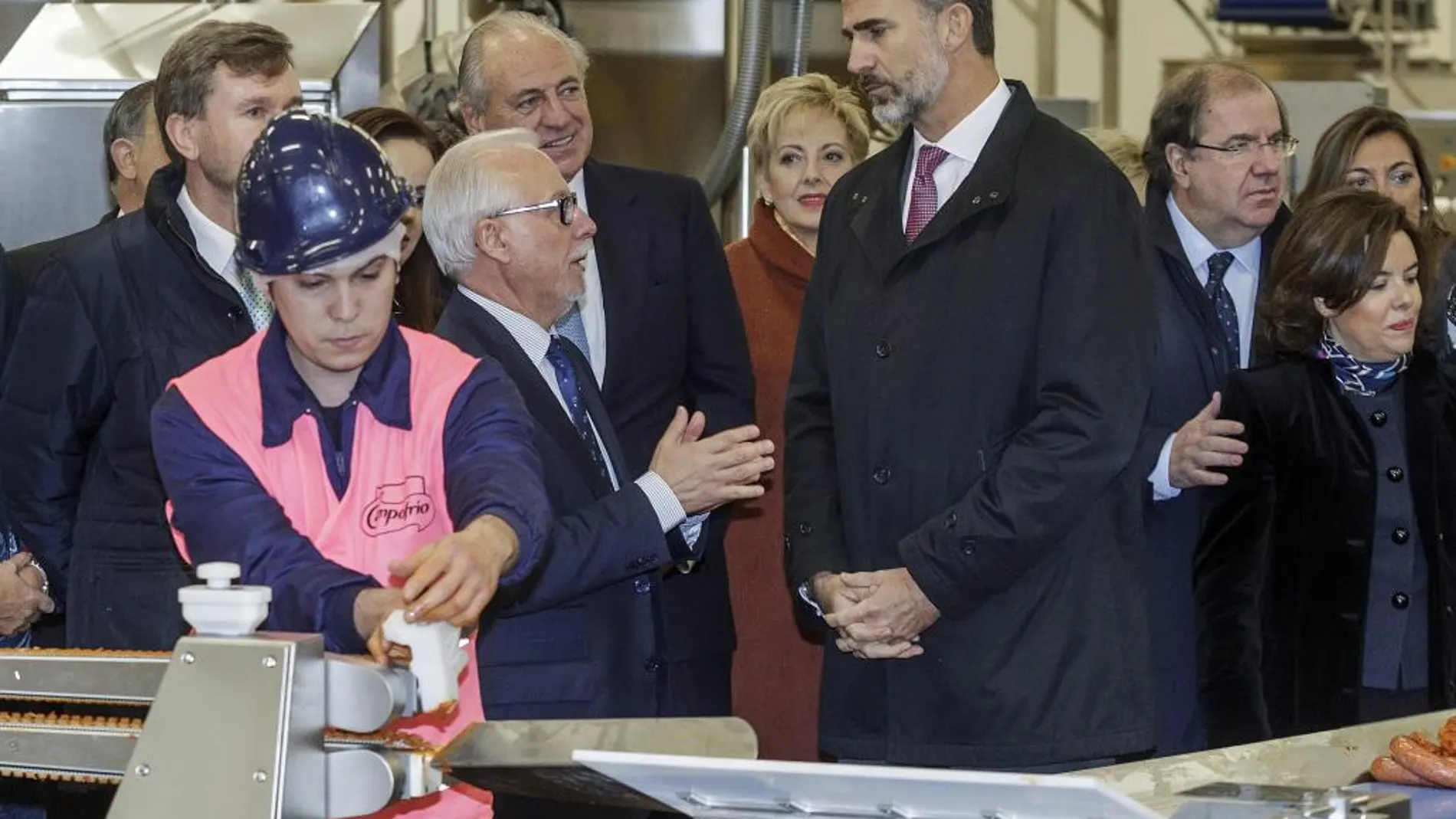 El Rey Felipe VI acompañado por el presidente de Castilla y León, Juan Vicente Herrera, y la vicepresidenta del Gobierno, Soraya Sáenz de Santamaría, durante la visita realizada hoy a las nuevas instalaciones de la fábrica de Campofrío en Burgos
