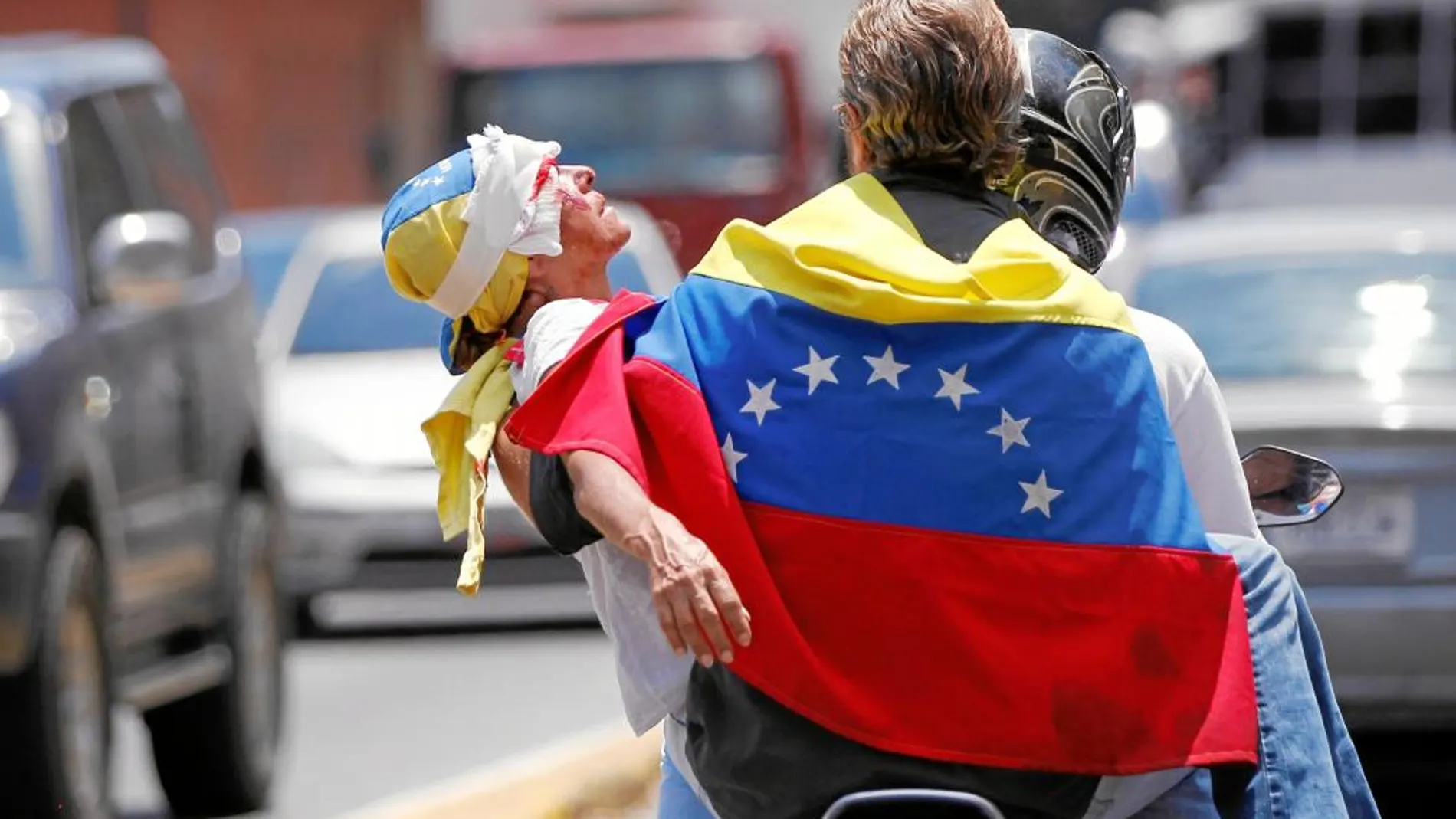 Un opositor es trasladado tras ser herido por la Policía chavista, ayer, en Caracas