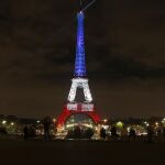 Vusta de la Torre Eiffel ilumindda con los colores de la bandera francesa