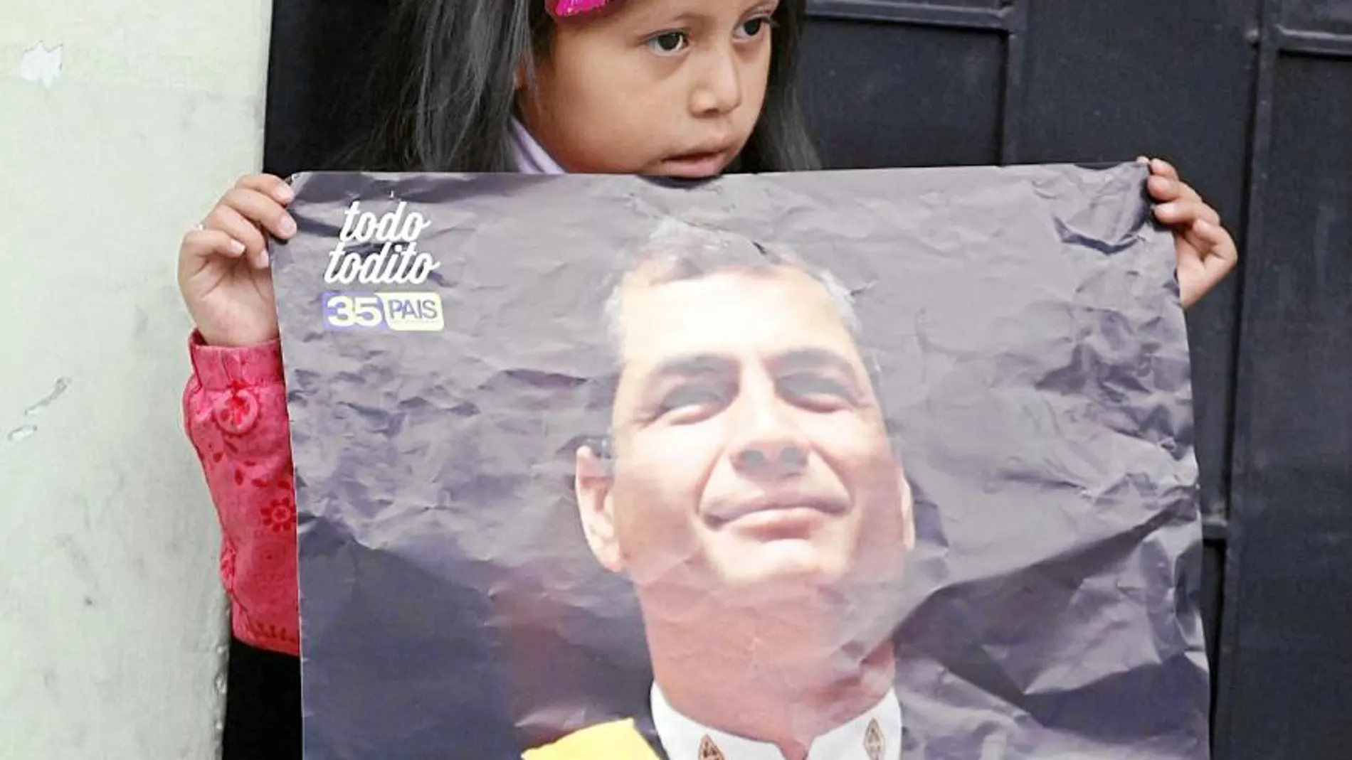 Una niña sostiene uno de los muchos carteles de Correa que estos días inundan Ecuador