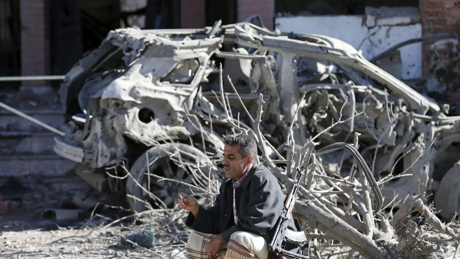 Un policía junto a un destrozado tras el ataque de la coalición