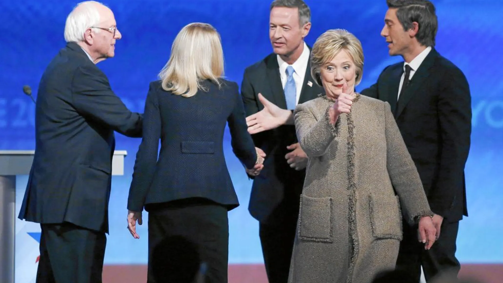 La precandidata demócrata a la Casa Blanca, Hillary Clinton, celebra su victoria en el tercer debate demócrata con sus adversarios de fondo