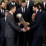 El Rey recibe de manos del capitán del Real Madrid de baloncesto, Felipe Reyes, el trofeo de la Copa del Rey