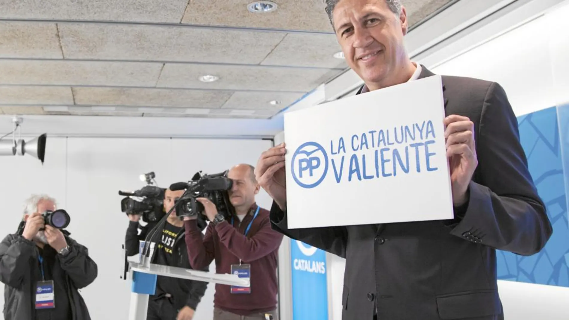 Xavier García Albiol mostrando un cartel con el lema de la campaña, ayer en la sala de prensa del PP