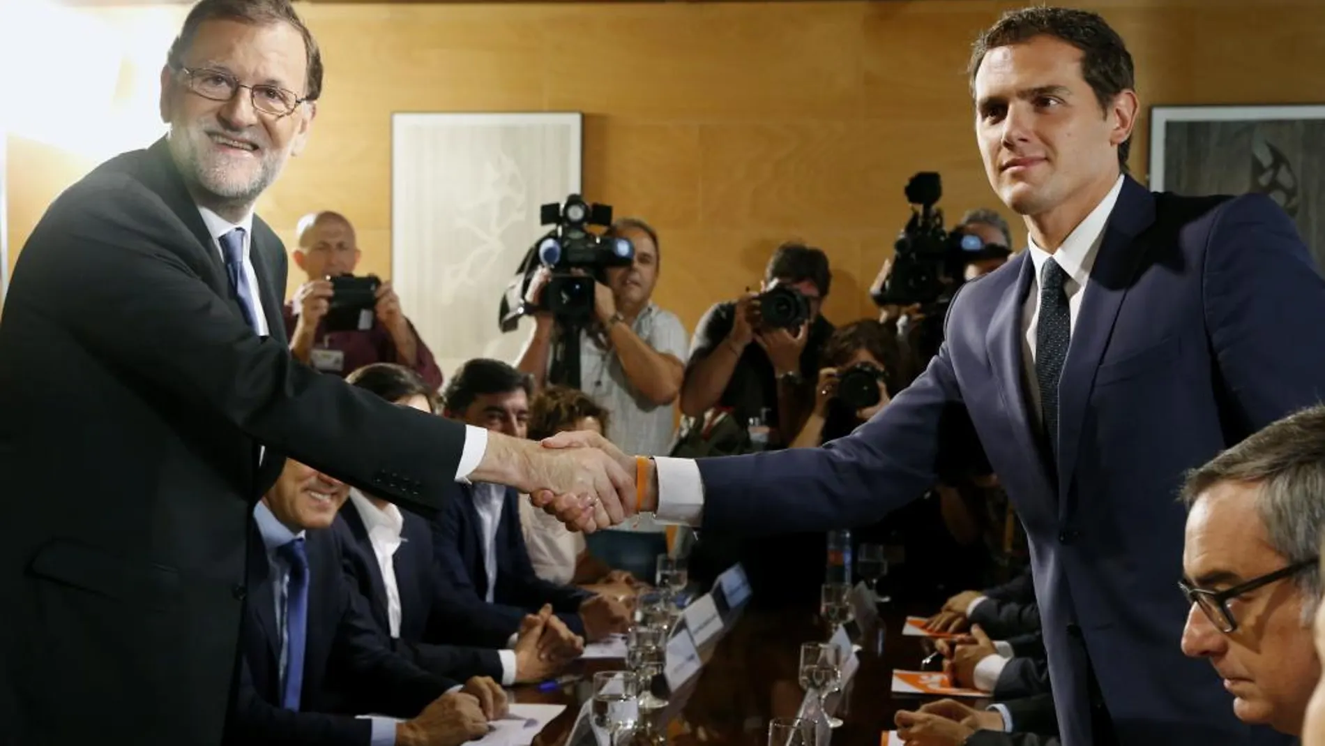Mariano Rajoy, iz., y el líder de Ciudadanos, Albert Rivera,se estrechan la mano durante la reunión de sus respectivas delegaciones