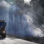 Un vehículo de la Unidad Militar de Emergencias transita por una carretera cerca de una zona incendiada, en Asturias