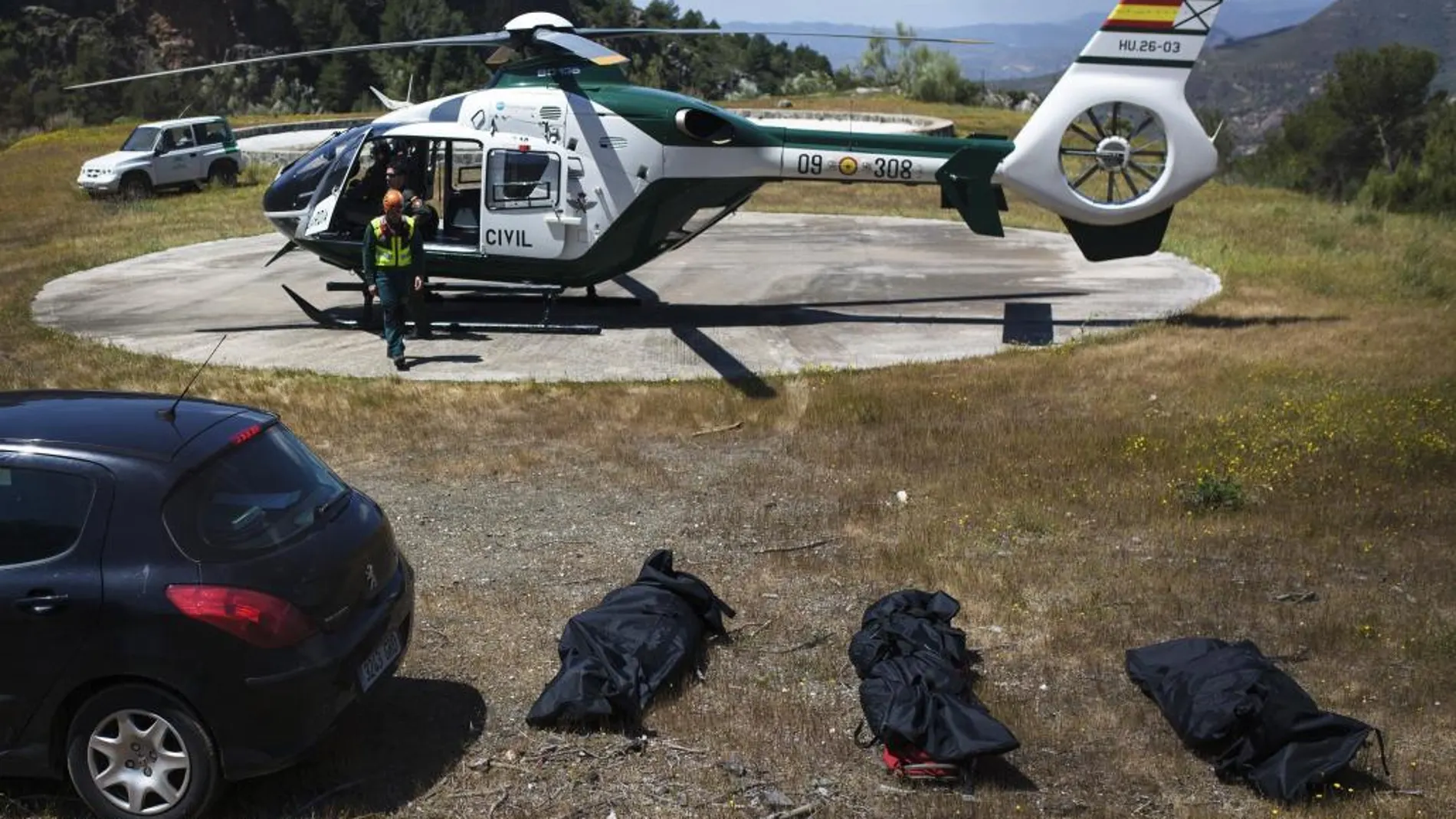 Los cuerpos de las tres personas fallecidas al estrellarse una avioneta en un paraje montañoso en Canillas de Aceituno (Málaga), tras ser rescatados hoy por un helicóptero de la Guardia Civil.