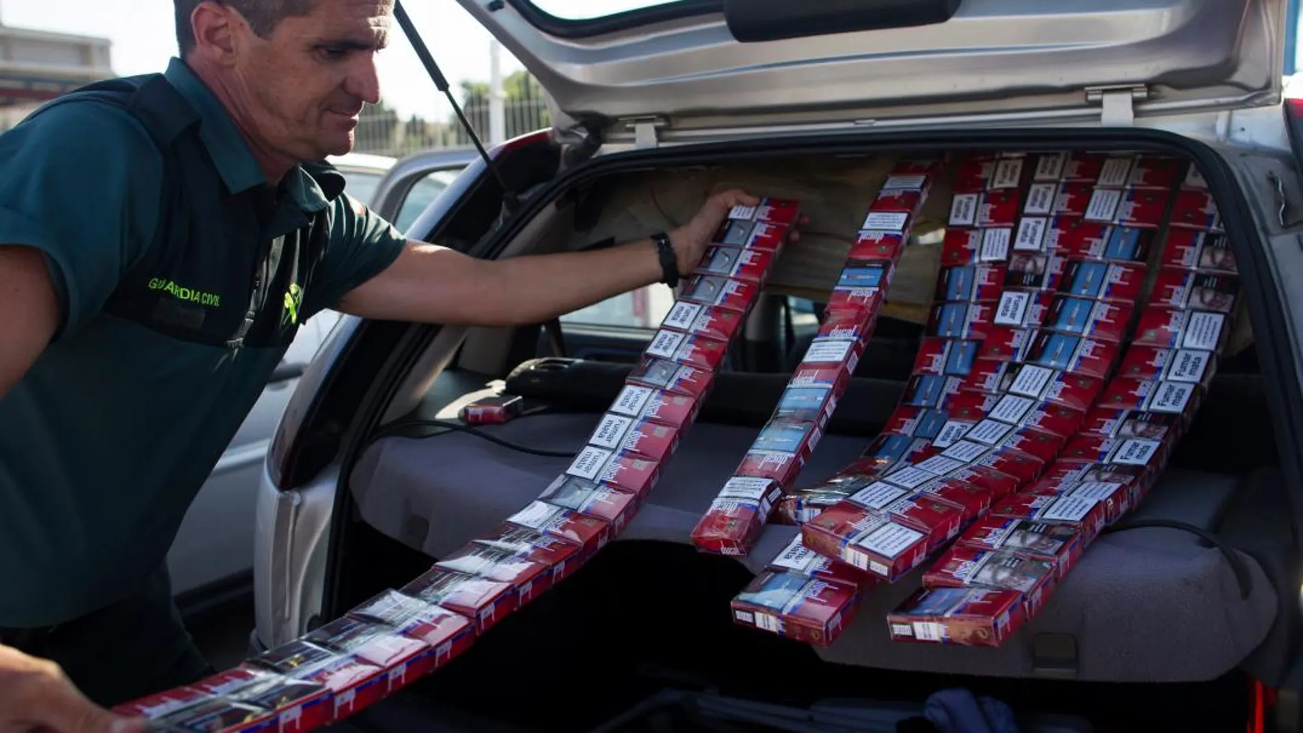 Un Guardia Civil extrae paquetes de tabaco ilegal de un coche en la Línea de la Concepción/Foto ALberto R. Roldán