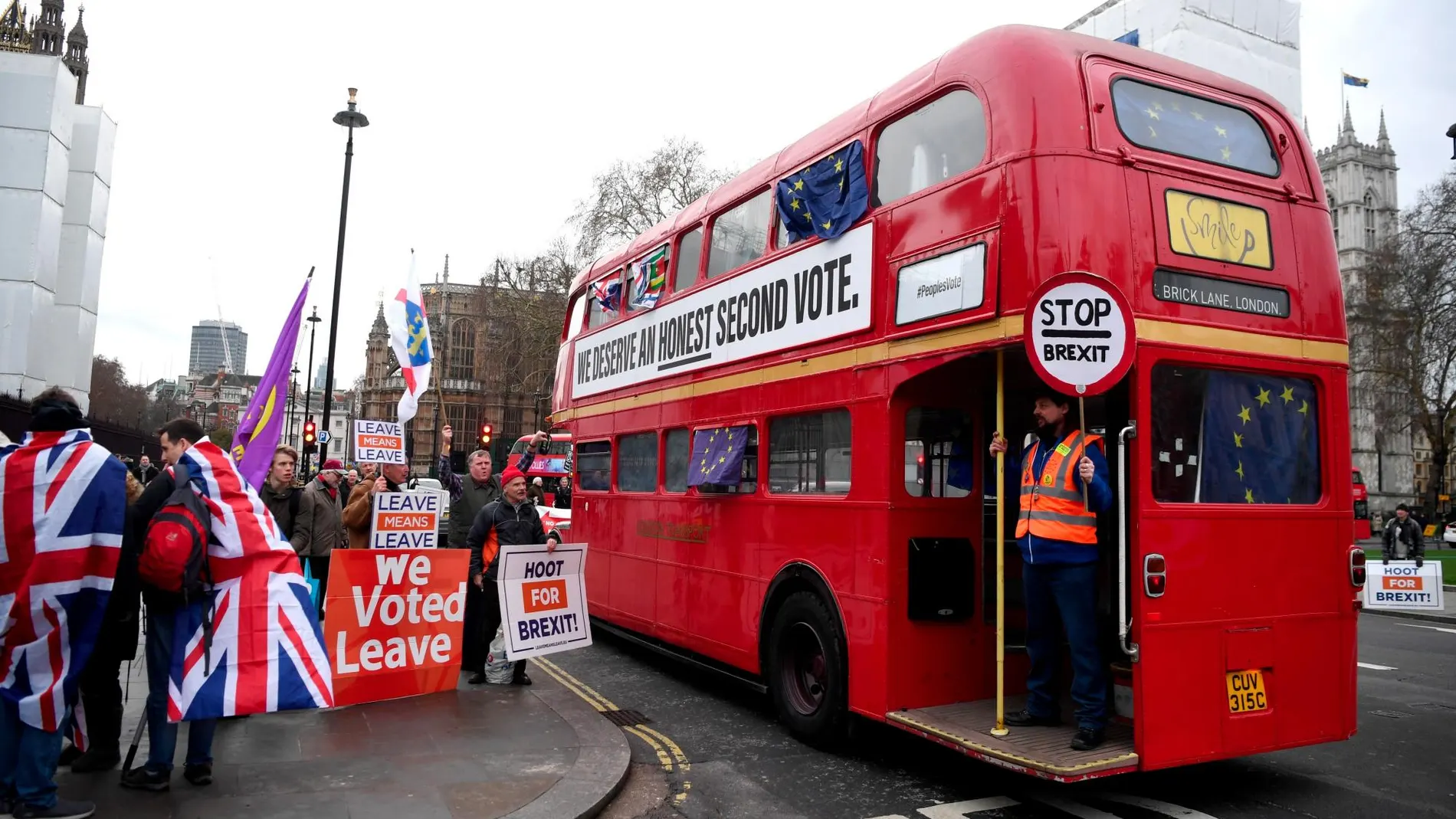 Manifestantes a favor del Brexit protestan frente a un autobús en el que pueden leerse consignas contrarias a la salida del país de la Unión Europea