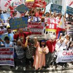 Manifestantes gritan consignas durante una protesta contra los reclamos territoriales de China, fuera de la oficina consular china en la ciudad de Makati, al sur de Manila