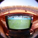 Aficionados siguiendo a través del ordenador un partido de fútbol desde la Monumental de Las Ventas