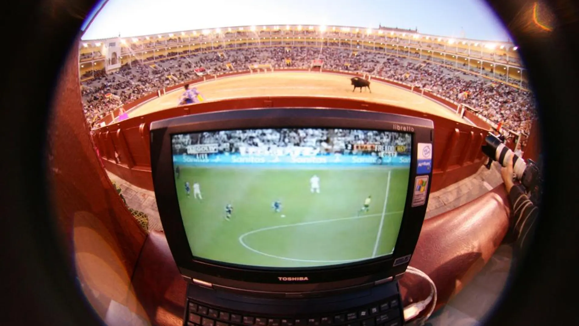 Aficionados siguiendo a través del ordenador un partido de fútbol desde la Monumental de Las Ventas