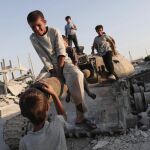 Varios niños sirios juegan con un tanque destrozado en la ciudad de Kobani