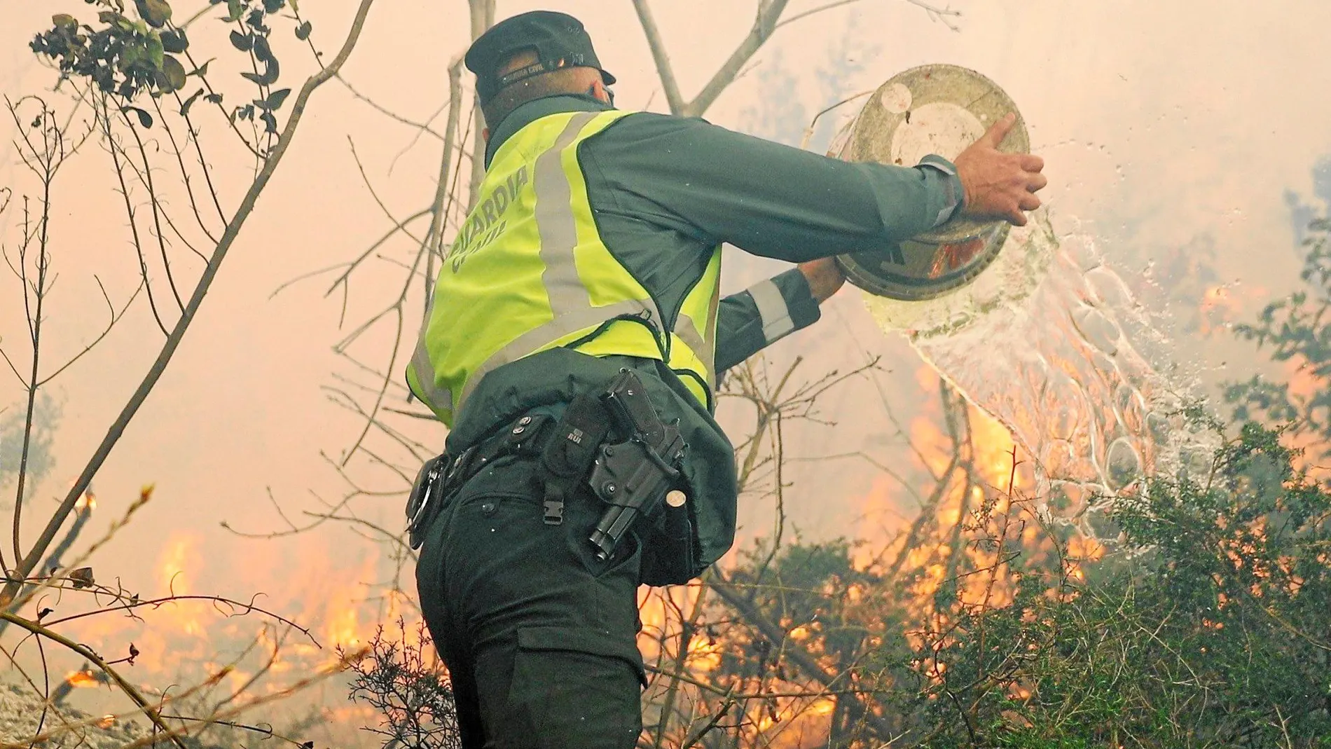 Un agente, ayer, ayudando en las labores de extinción del incendio que afecta a Dodro y Rianxo