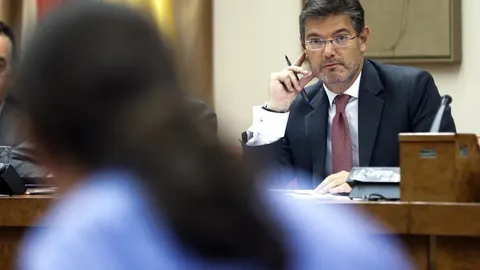 El ministro de Justicia, Rafael Catalá, mira hacia el líder de Podemos, Pablo Iglesias, durante su comparecencia en la Comisión de Justicia
