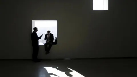 Dos usuarios del MWC con sus móviles