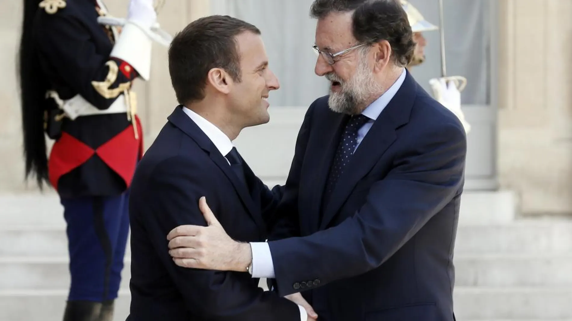 El presidente francés, Emmanuel Macron, da la bienvenida al jefe del Gobierno español, Mariano Rajoy, antes de su reunión en el palacio del Elíseo en París.